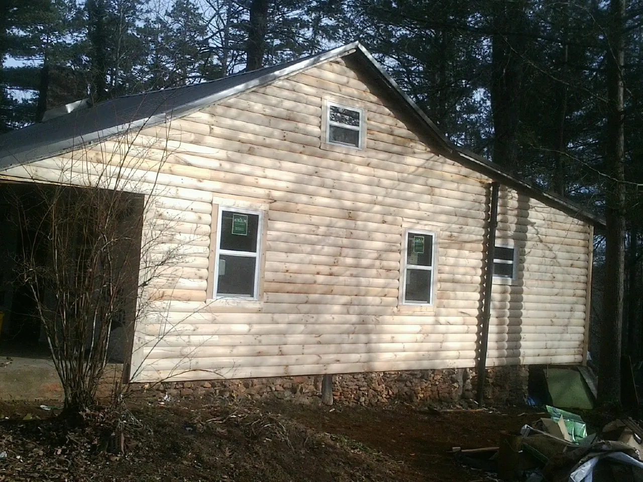 New log siding and dark metal roofing on a gable end in Alexandria